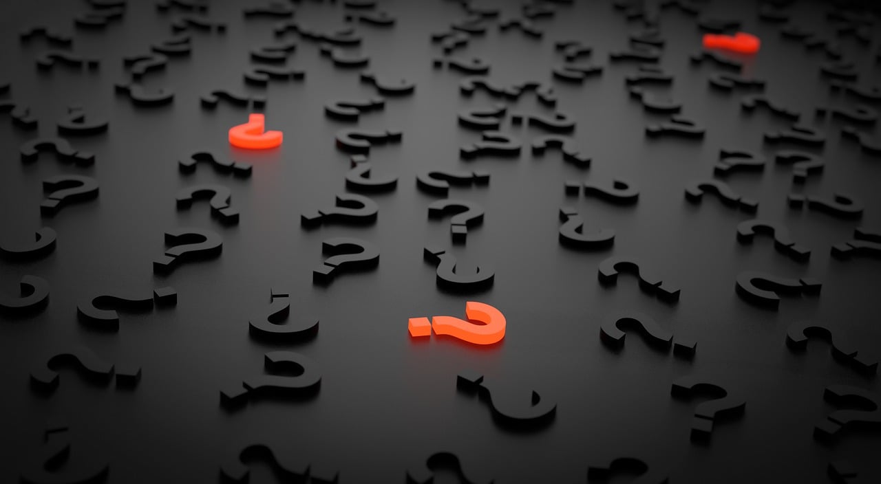 Two red question marks amongst scattered black question marks