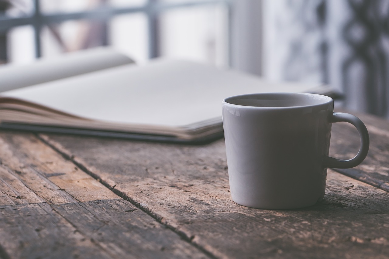 Cup next to open notebook