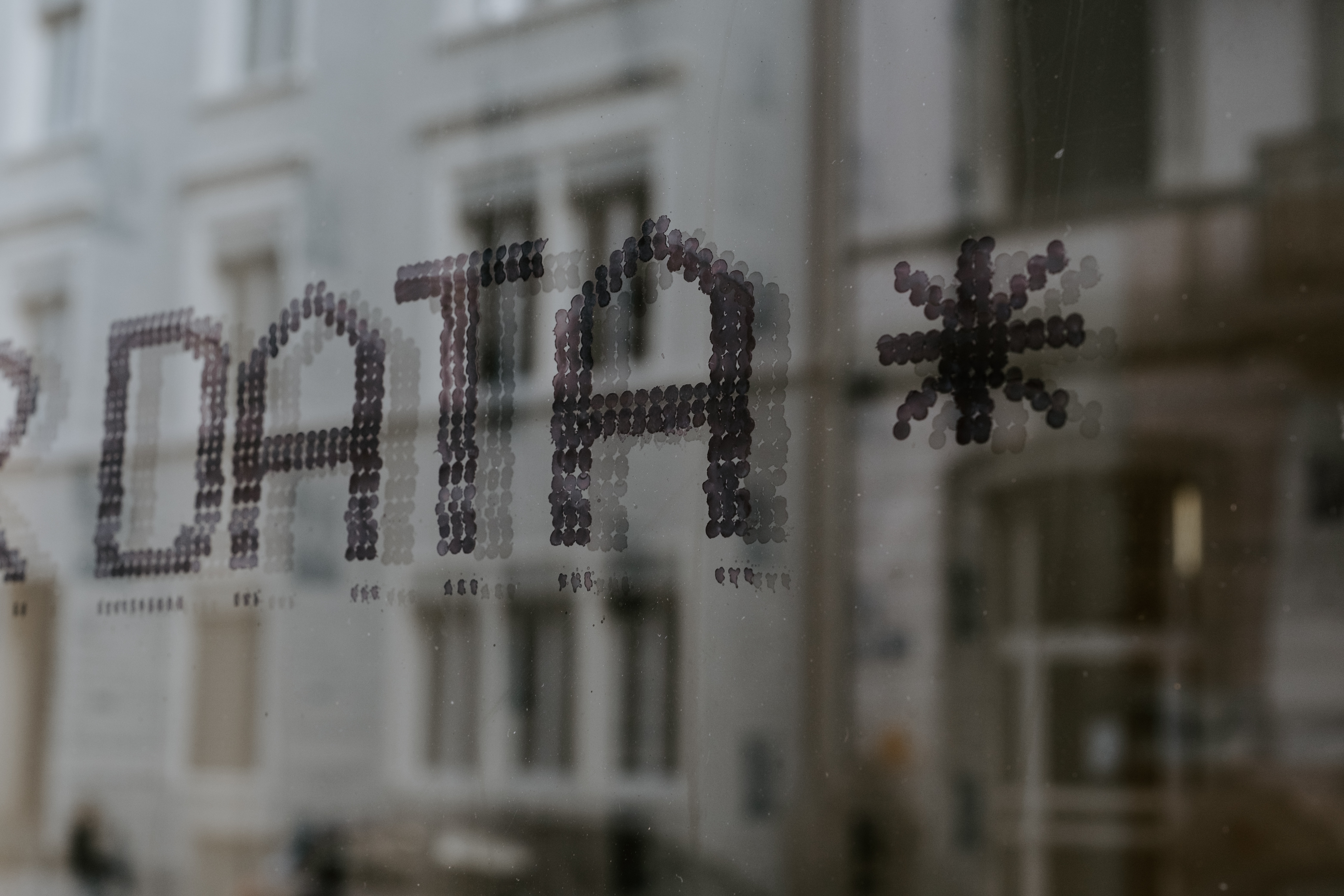 Close-up of display screen with reflection of buildings
